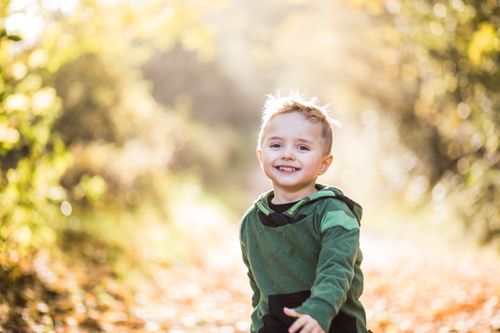 Free A happy young boy enjoying a sunny autumn day outdoors, surrounded by nature. Stock Photo