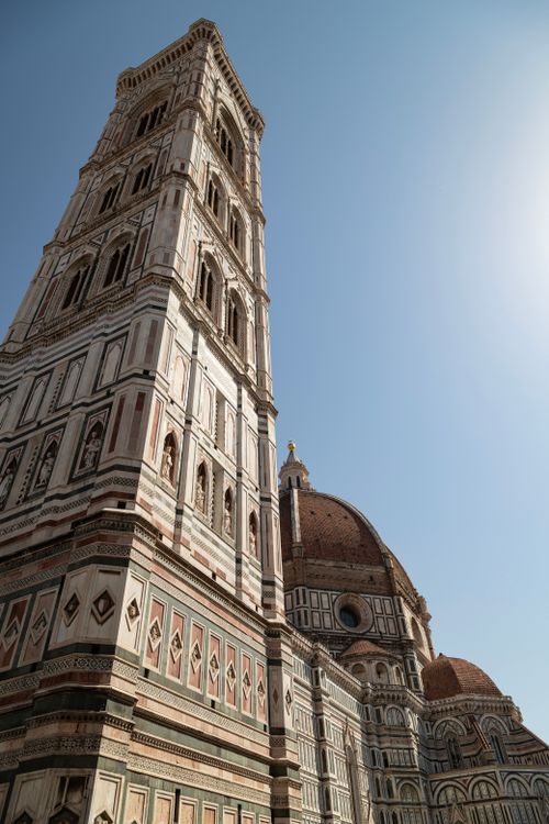 Free View of the Florence Cathedral and Giotto's Campanile under clear blue sky, showcasing Gothic architecture. Stock Photo