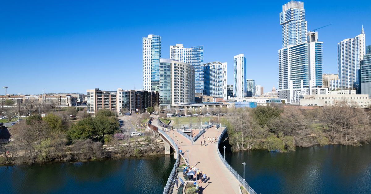 Stunning aerial view of Austin's modern skyline with a scenic riverfront bridge.