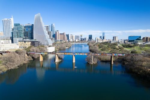 Free Stunning aerial view of Austin, Texas skyline featuring a graffiti-covered bridge over the river. Stock Photo