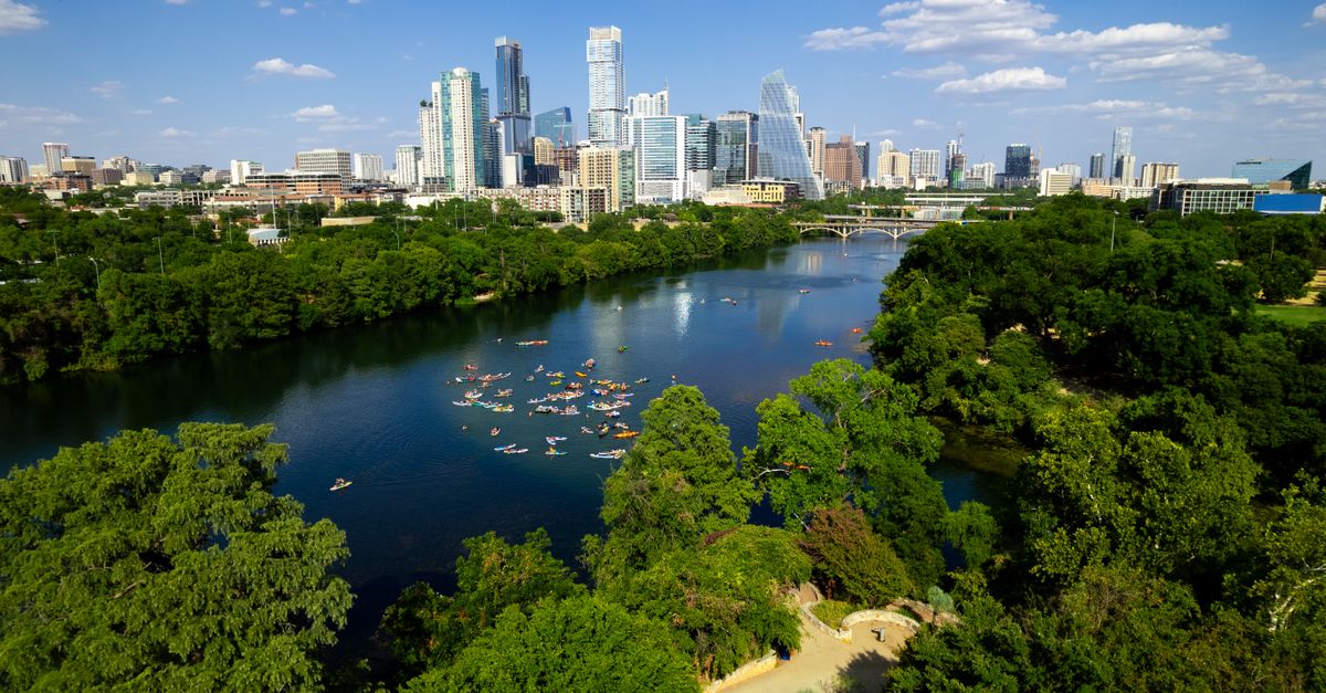 Scenic aerial view of downtown Austin, Texas, featuring the river and lush greenery.