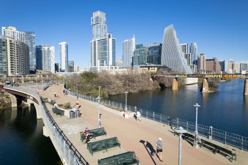 Free Aerial view of Austin's downtown skyscrapers and Lady Bird Lake footbridge on a sunny day. Stock Photo