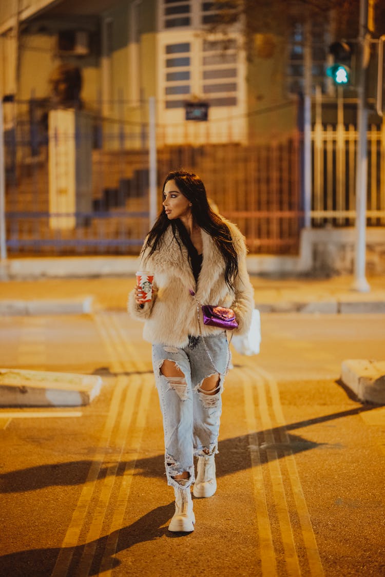 Woman In Jeans And Coat Walking On The Street 