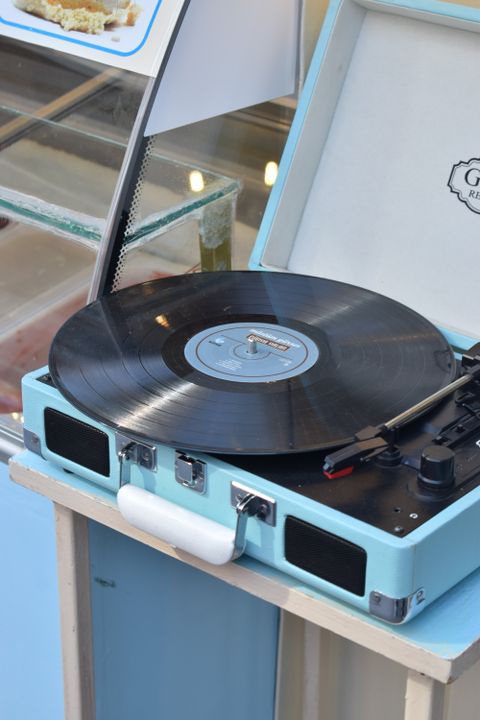 Light blue suitcase record player playing a vinyl record