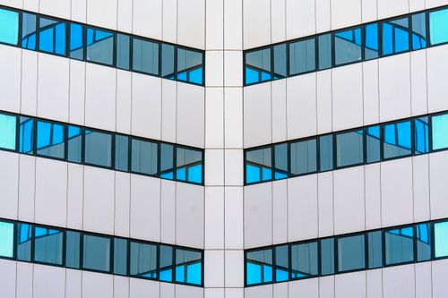 Free Symmetrical modern building facade in Rijswijk, Netherlands with striking blue glass windows. Stock Photo