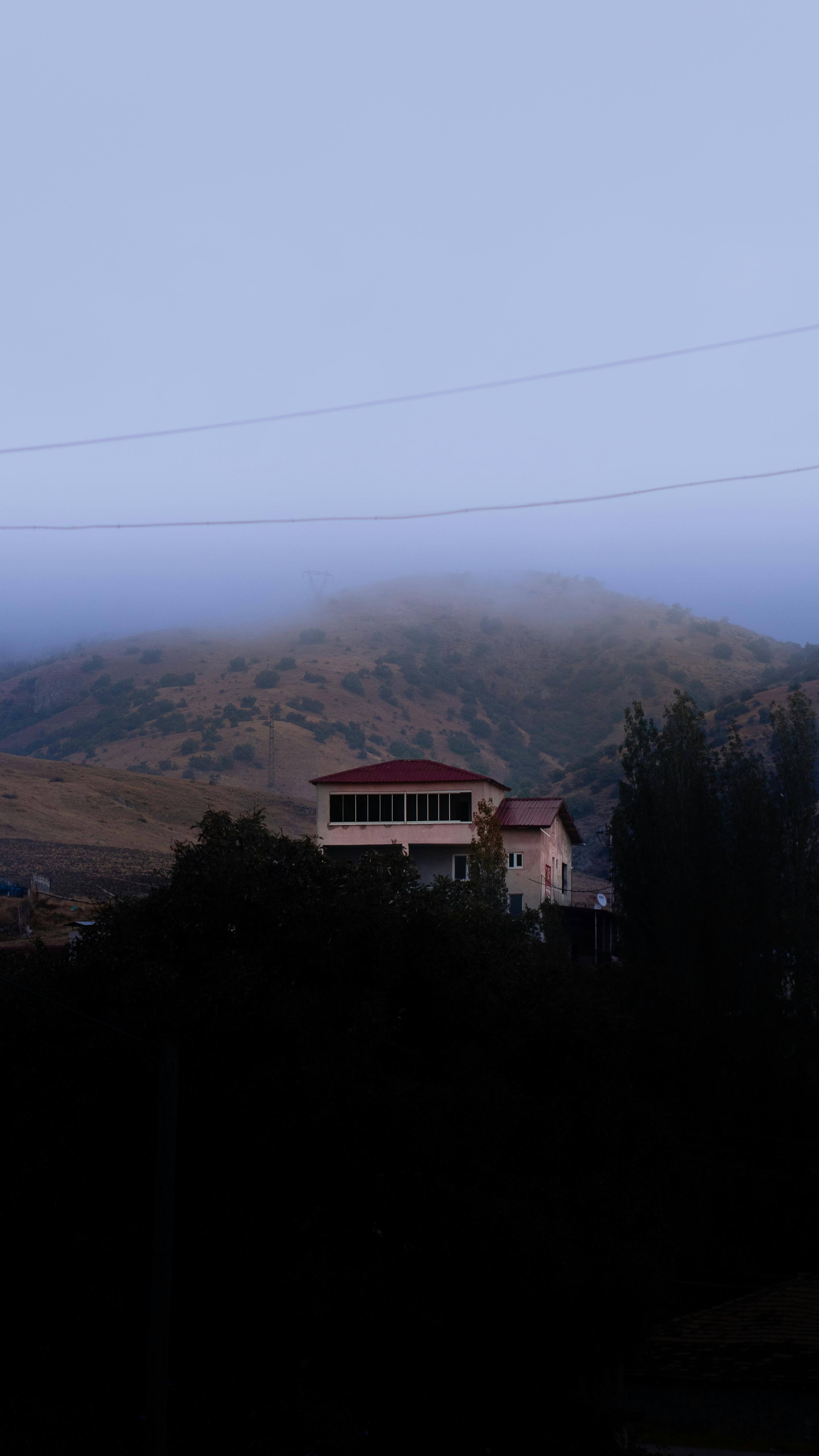 a house is seen in the foggy sky