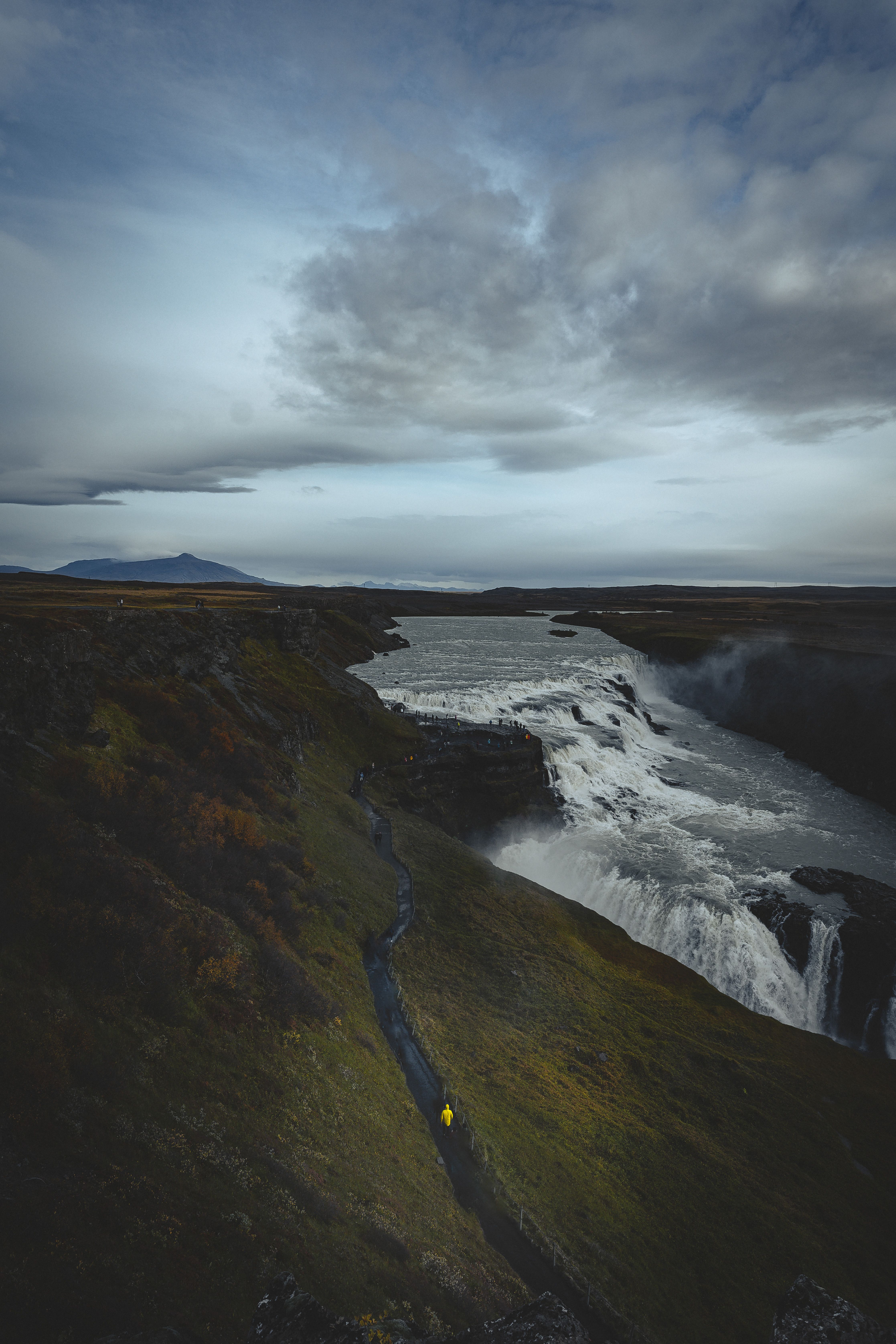 A person walking along a path near a waterfall · Free Stock Photo