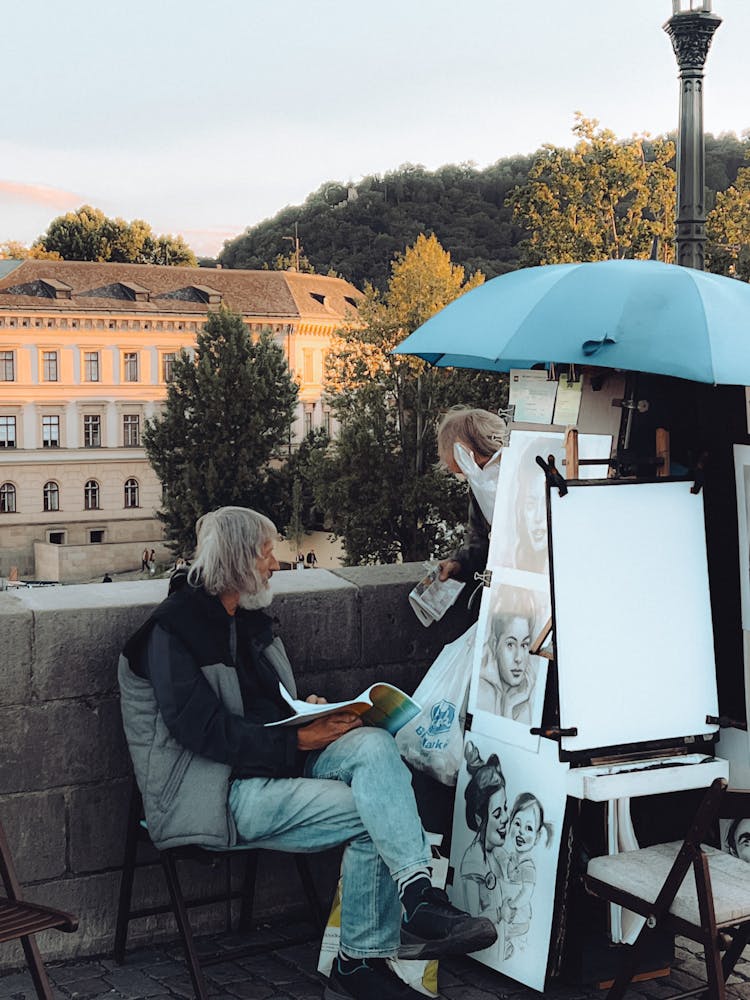 Painter Sitting On Sidewalk In Paris