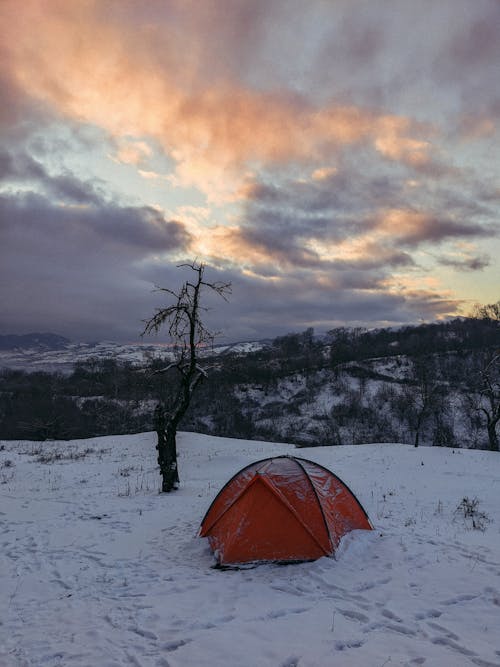 A tent is pitched on a snowy hillside