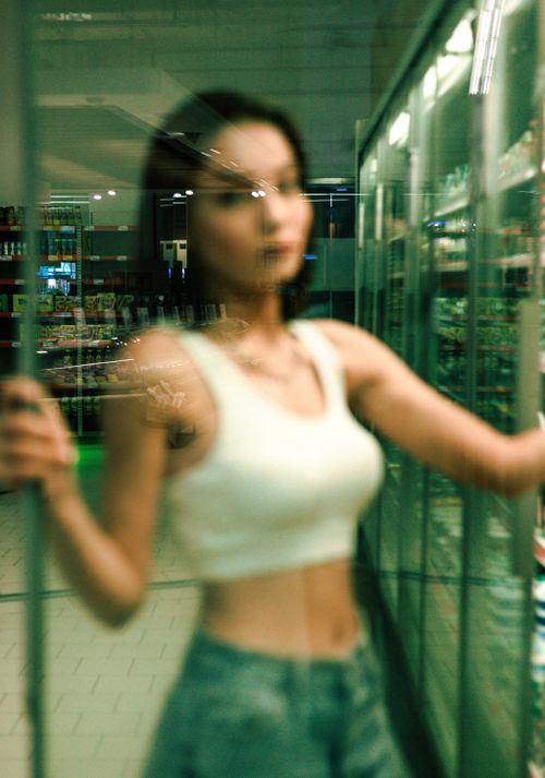 Free Artistic blurred portrait of a woman in an urban environment with glass reflections. Stock Photo