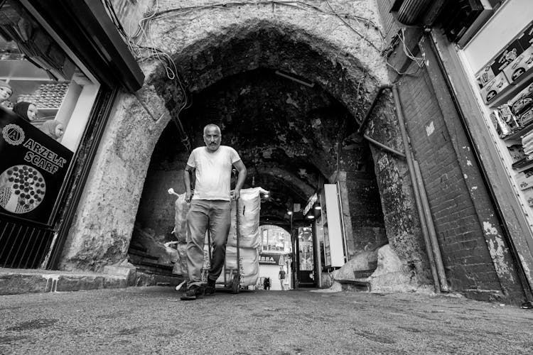 Elderly Man With A Cart On A Street In Black And White 