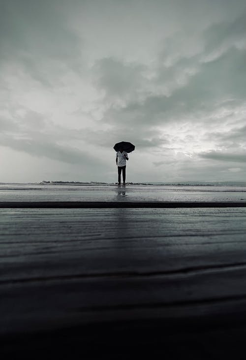 Man with Umbrella on Sea Shore