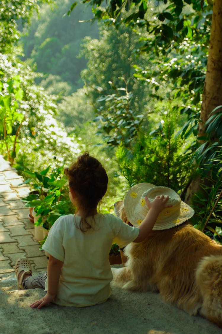 Girl Sitting With Dog In Hat