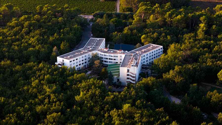 Vue aérienne d’un hôtel moderne au milieu d’une forêt luxuriante