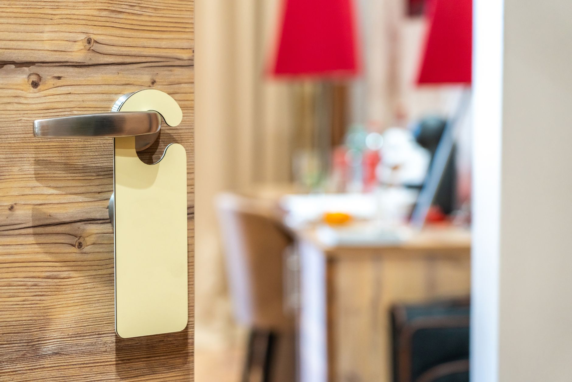 Stylish hotel room door handle with a blank sign in a well-decorated interior. Related image for Guest Experience: What Is Changing Across Global Hospitality.