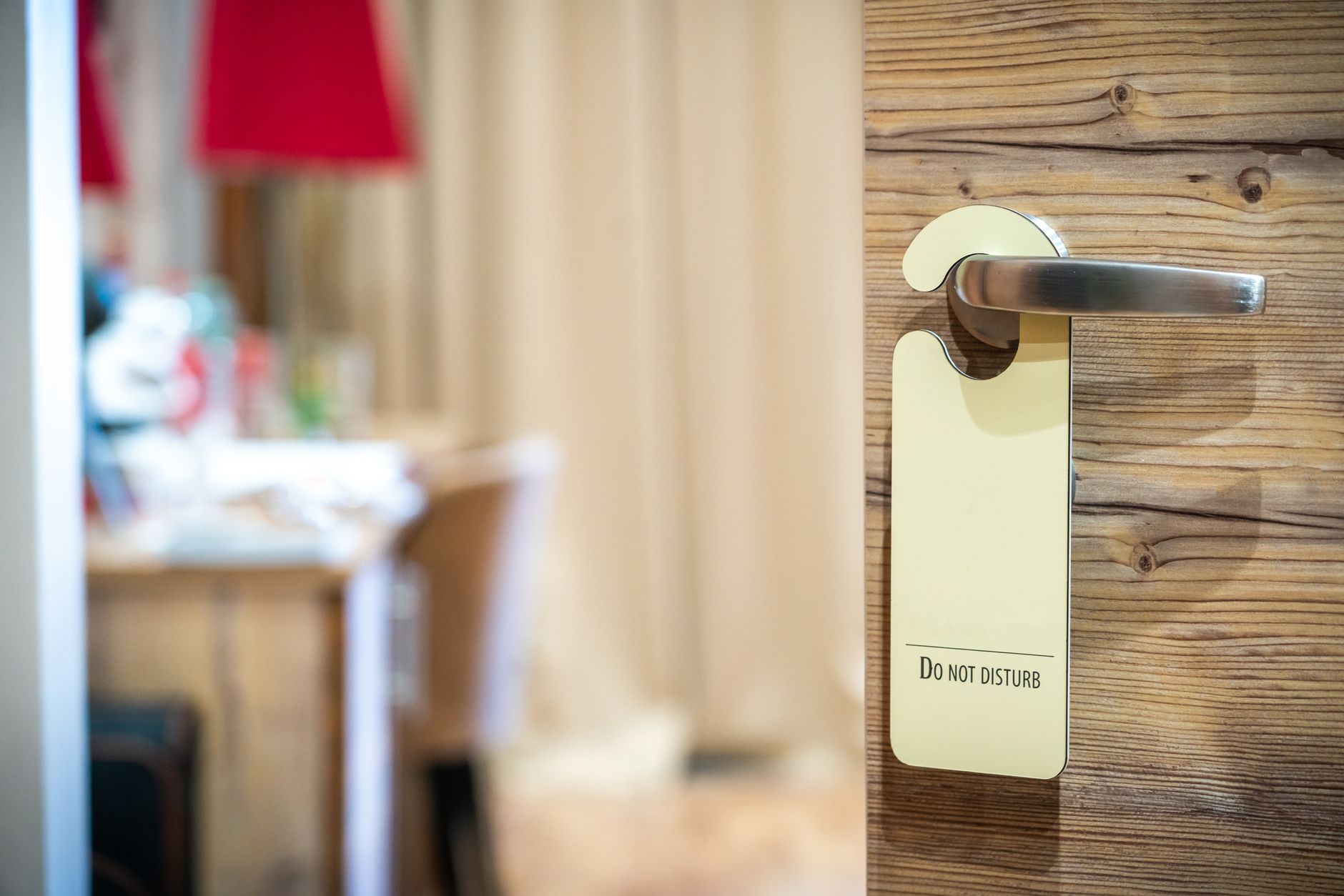 A hotel room door with a 'Do Not Disturb' sign hanging on the handle, conveying privacy.
