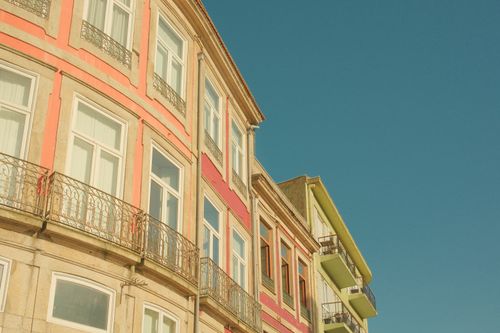 Free Vibrant city architecture with traditional facades against a clear blue sky in Porto, Portugal. Stock Photo