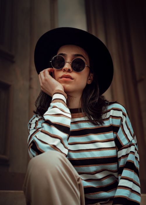 Free A fashionable woman in sunglasses and a striped shirt poses outdoors in Istanbul. Stock Photo