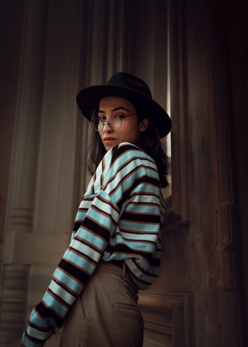 Free Stylish woman in striped shirt and hat poses indoors, Istanbul setting. Stock Photo
