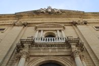 Low angle view of a historic stone building facade in Chiclana de la Frontera, Spain with classical architecture.