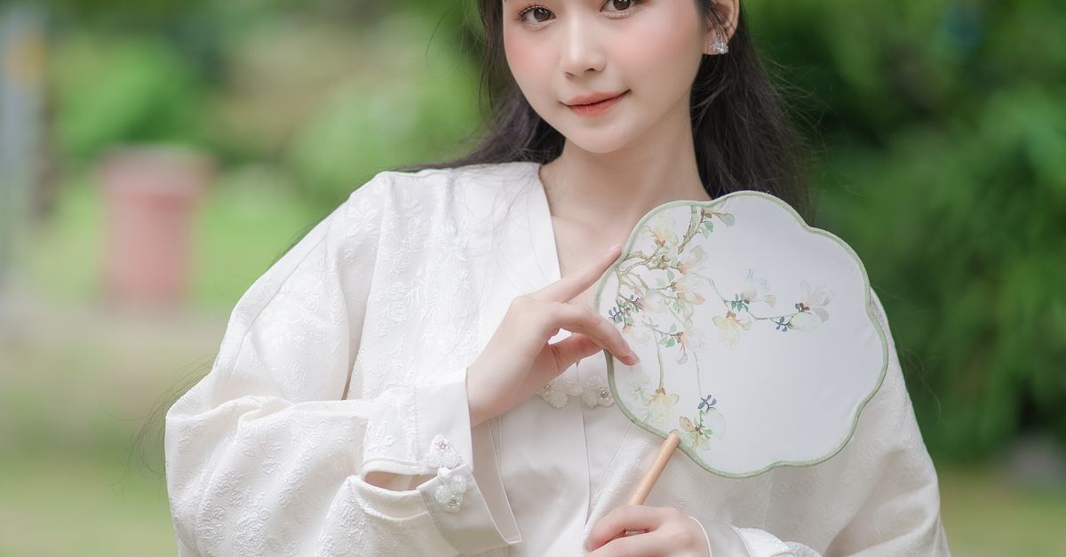Brunette Woman in White Blouse Posing with a Tuanshan Fan · Free Stock ...