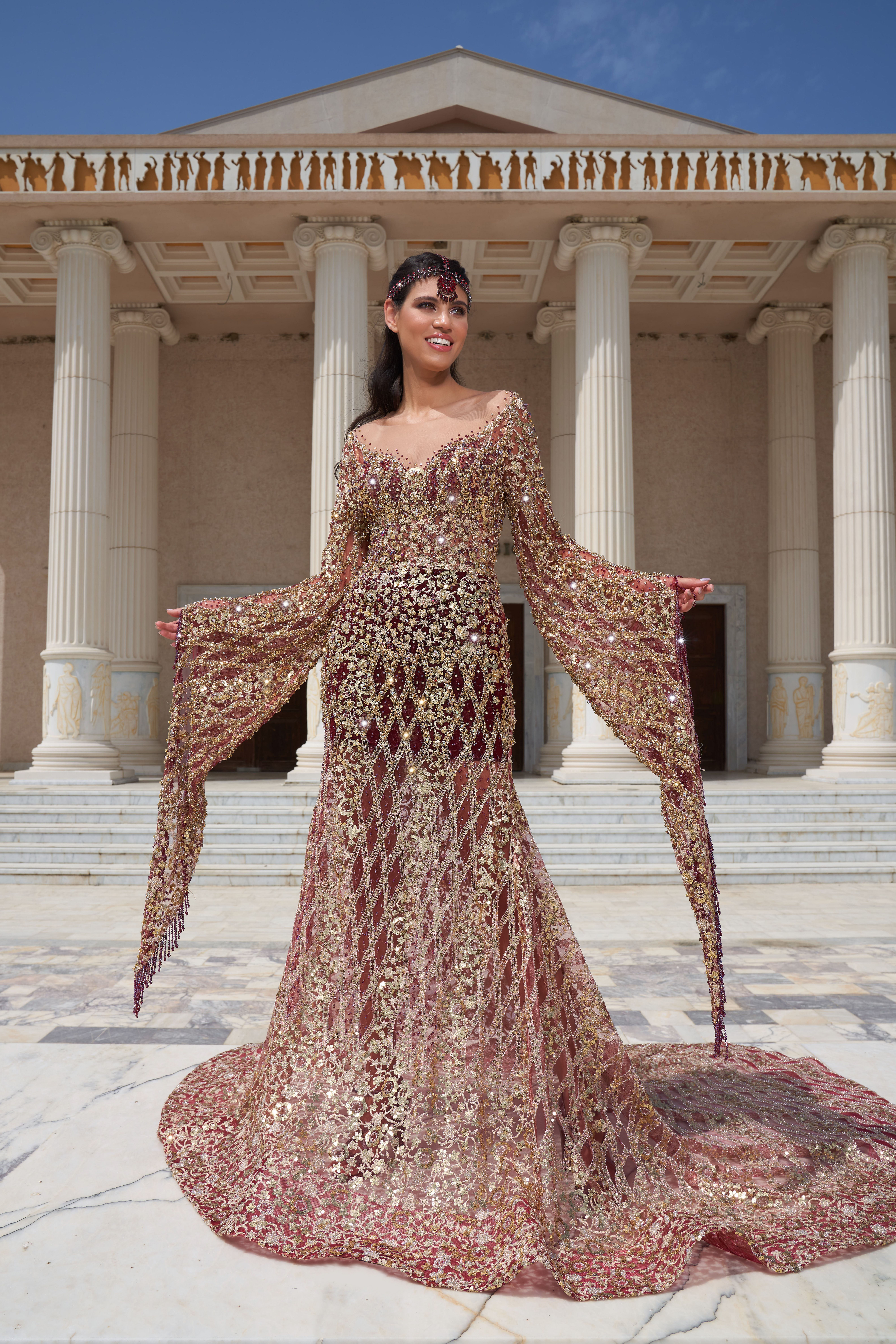 Smiling woman in luxurious gown poses by grand columns in İzmir, Türkiye.