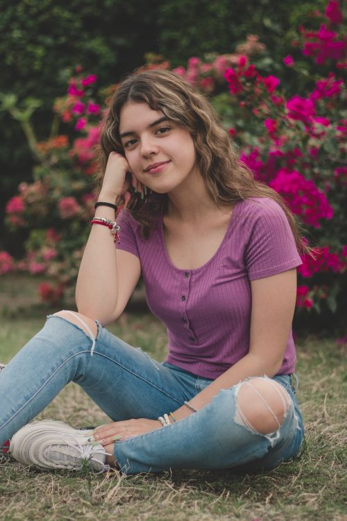 Smiling Woman in Torn Jeans Sitting on Ground · Free Stock Photo
