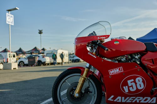 A red motorcycle parked in a parking lot