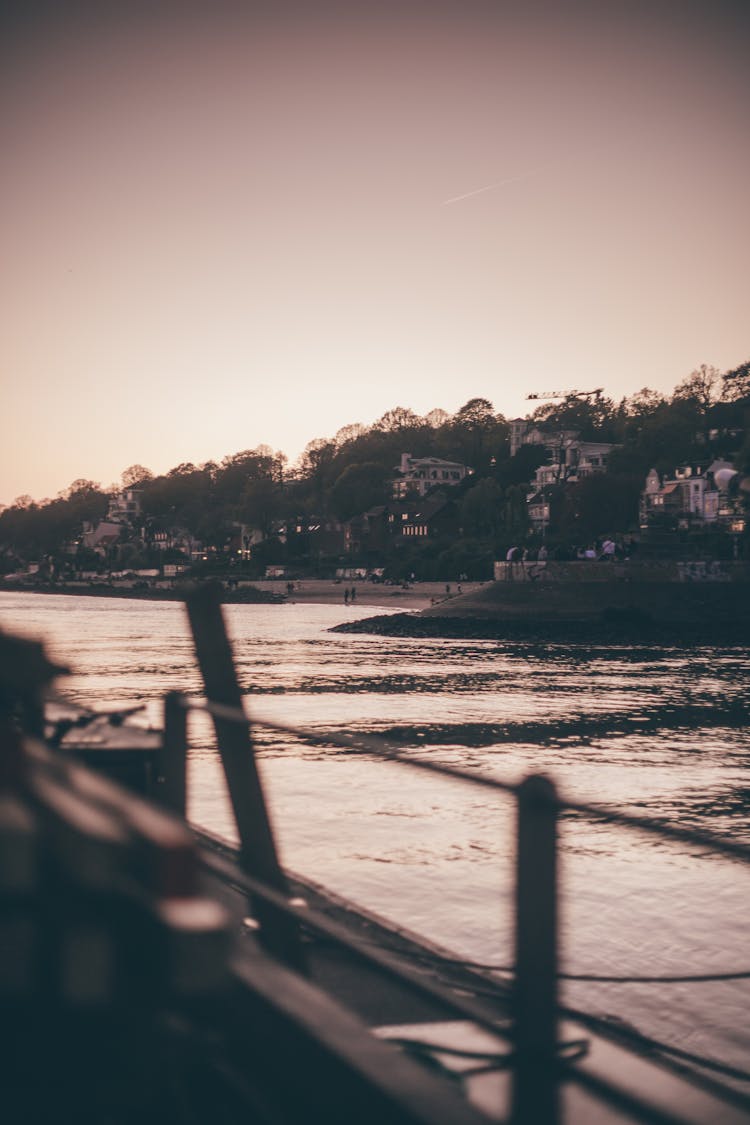 People Walking On Seashore In Coastal Town On Sunset