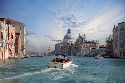 View of a Boat on Canal Grande and the Santa Maria della Salute in the Background in Venice, Italy 