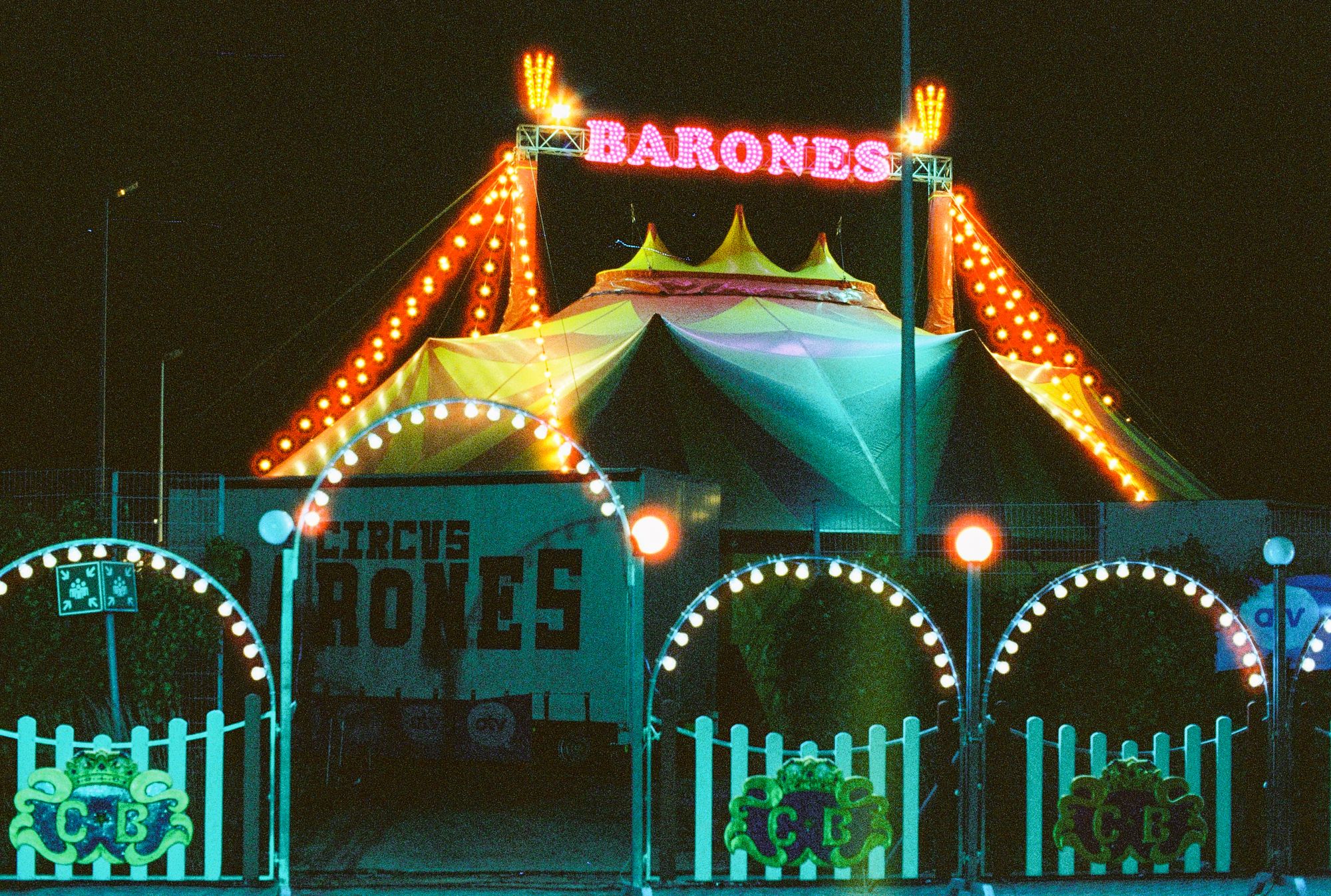 Vibrant neon circus tent with colorful lights during nighttime.