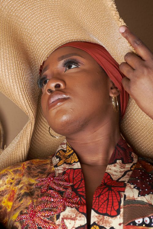 Free A fashionable woman poses with a large sun hat, showcasing bold style and elegance. Stock Photo