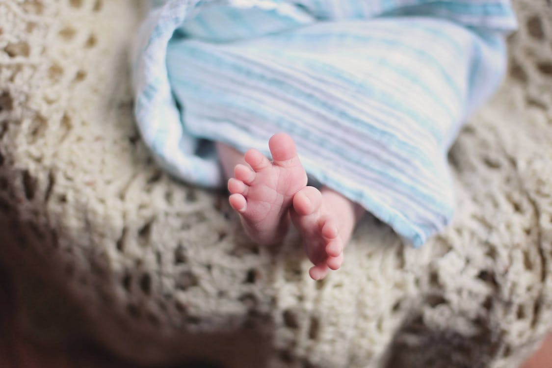無料 青い毛布の下の赤ちゃんの足 写真素材