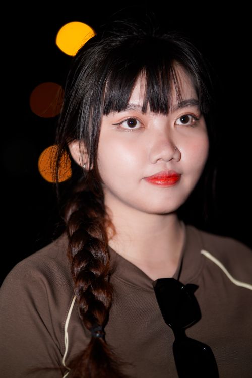 Free Captivating night portrait of woman with striking red lipstick and braided hair. Stock Photo