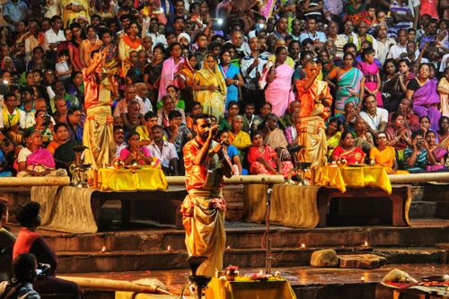 Free Colorful Hindu aarti ceremony with performers in traditional clothing and a large devoted crowd. Stock Photo