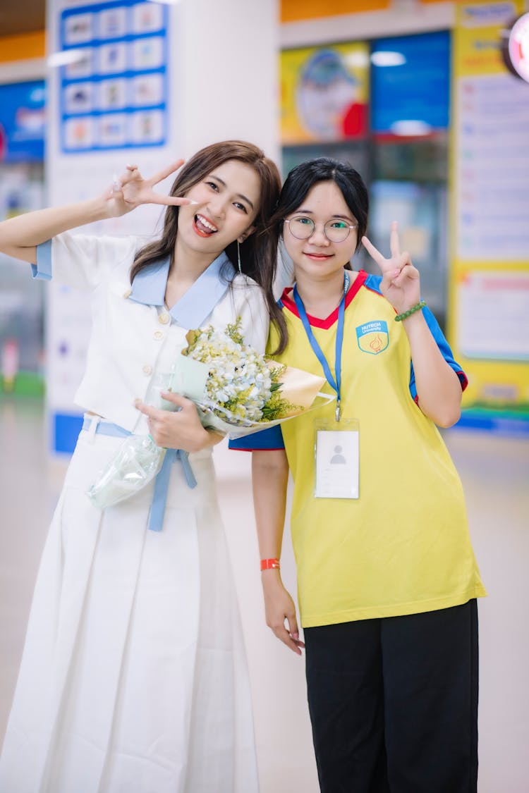 Smiling Asian Woman Posing With Teenage Girl In Glasses