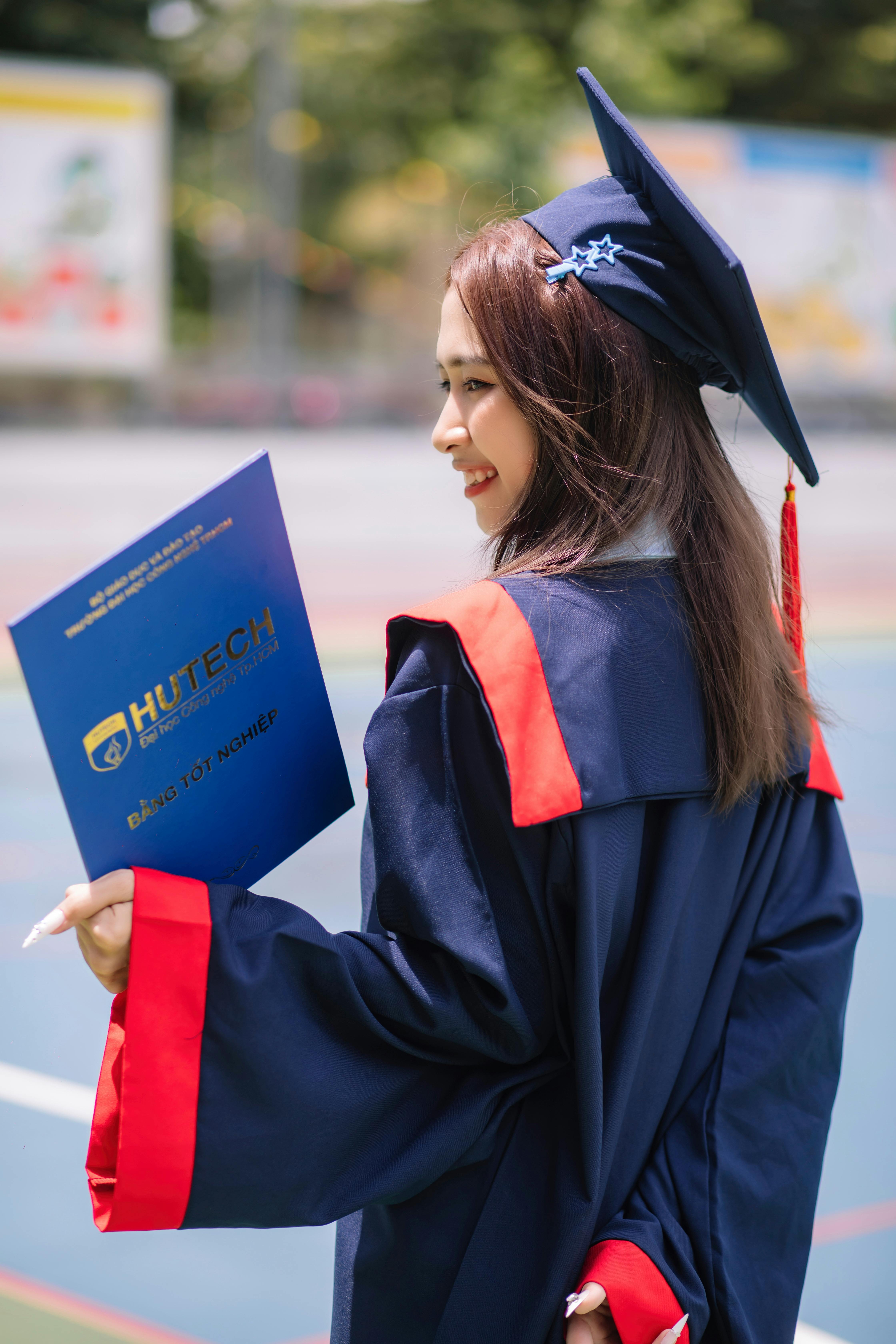 A young female graduate against the background of university graduates.  Stock Photo