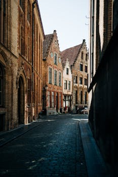 A picturesque cobblestone street in Bruges, Belgium showcasing historic architecture.