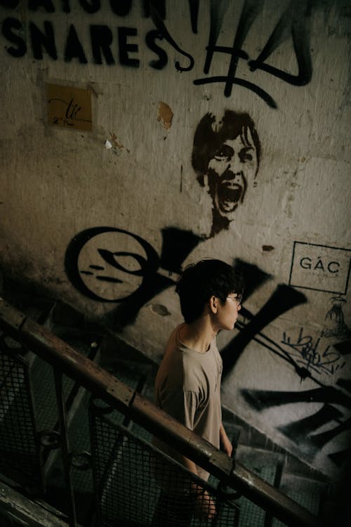 Man Walking Down Staircase against Mural on Wall