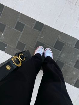 Top-down view of casual sneakers on pavement, showcasing urban fashion style.