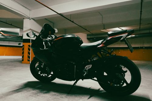 Free A stylish motorcycle parked in a dimly lit urban parking garage, showcasing modern design. Stock Photo