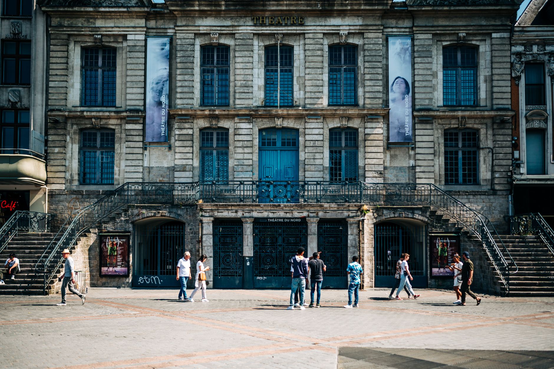 Théâtre du Nord's historic facade in Lille, France, with visitors exploring the urban landscape.