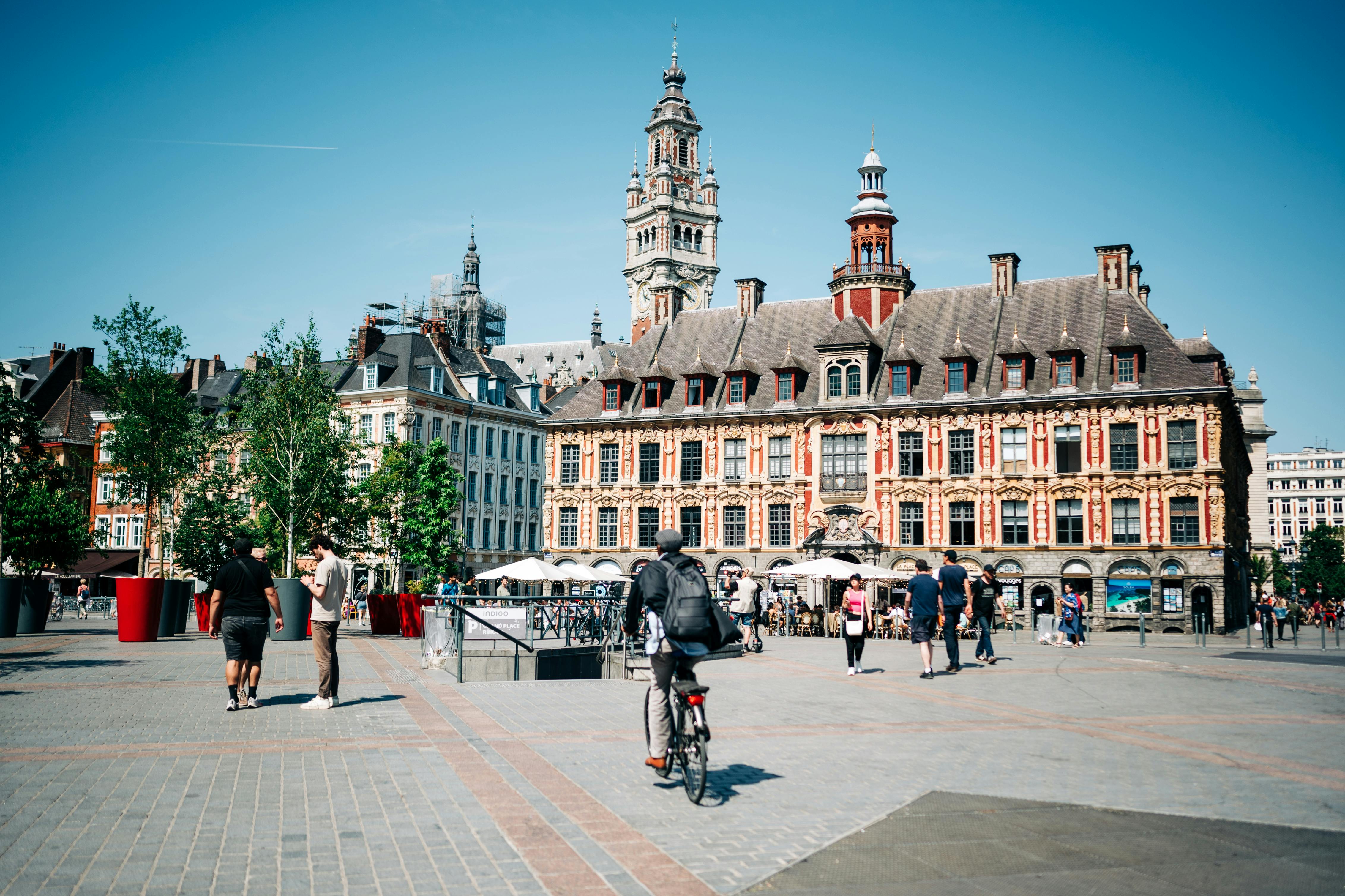 Free Lively city square in Lille with historic architecture and people enjoying a sunny day. Stock Photo