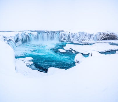 Captured in Iceland, the frozen Godafoss waterfall offers a breathtaking winter scene.