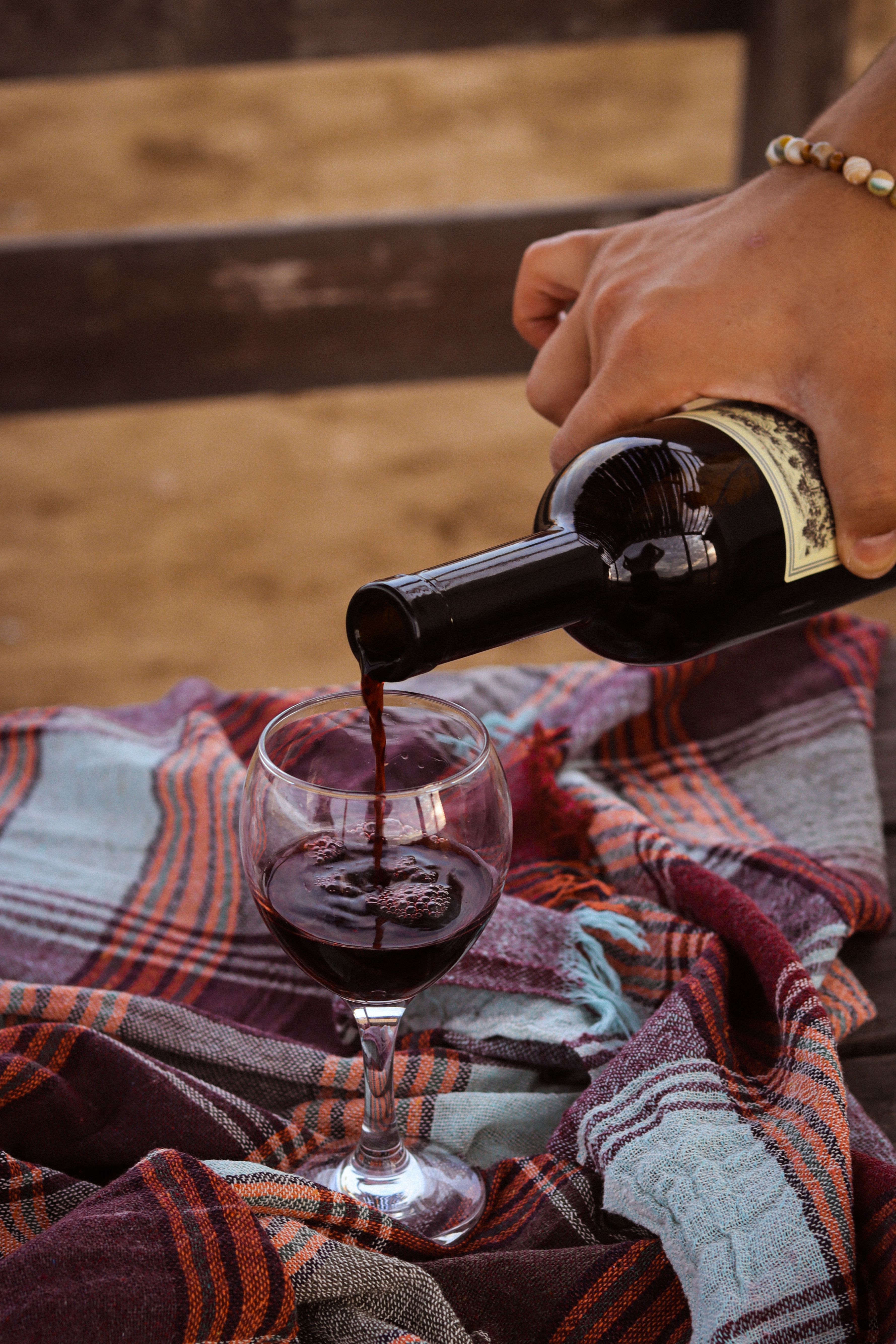 Red wine glass served outdoors on a plaid