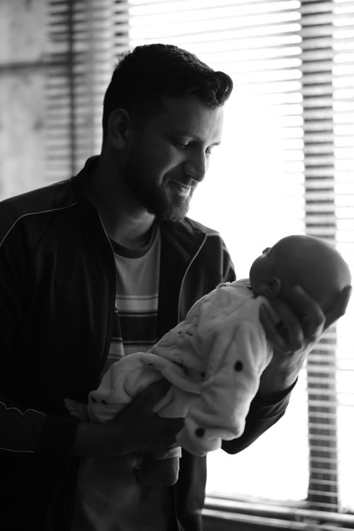 Free Captivating black and white portrait of a father holding his baby, filled with warmth and tenderness. Stock Photo