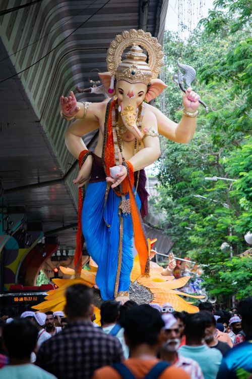 Free Vibrant Ganesh Chaturthi celebration with a large idol in Mumbai, India attracting a lively crowd. Stock Photo