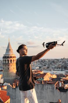 A man flies a drone in Istanbul, capturing stunning city views during sunset.