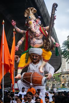 Vibrant Ganesh Chaturthi parade with traditional Ganesha idol in Mumbai, India.