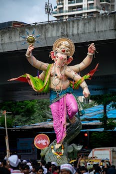 Colorful Ganesh statue during Mumbai's lively Ganesh Chaturthi festival parade.